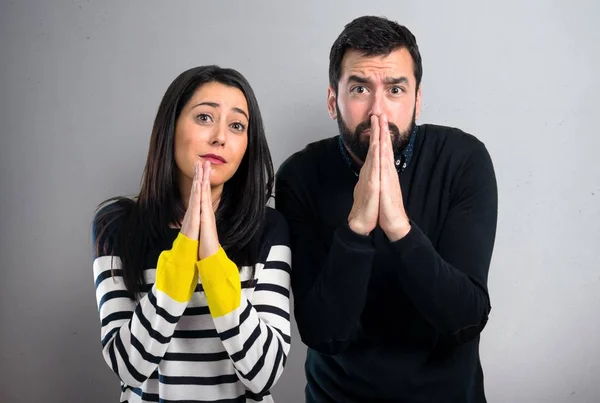 Pareja Suplicando Sobre Fondo Gris —  Fotos de Stock