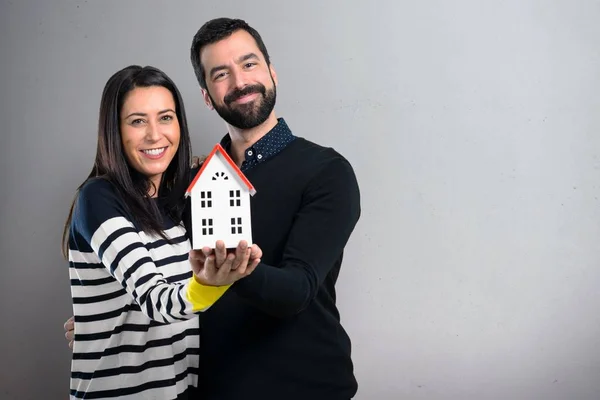 Couple Holding Little House Grey Background — Stock Photo, Image