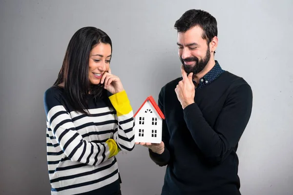 Couple Holding Little House Grey Background — Stock Photo, Image