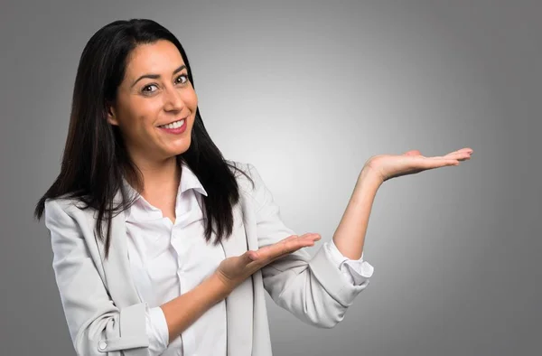 Mujer Bonita Presentando Algo Sobre Fondo Gris — Foto de Stock