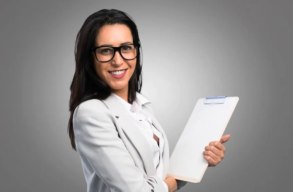 Mujer Bonita Con Gafas Sosteniendo Portapapeles Sobre Fondo Gris —  Fotos de Stock