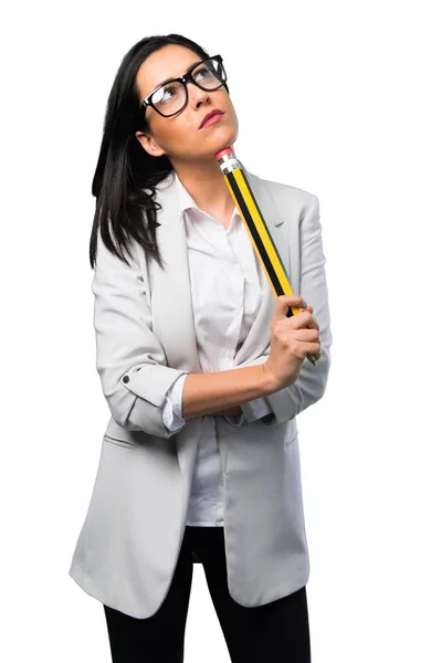 白い背景の大きな鉛筆を保持しているメガネをきれいな女性 — ストック写真