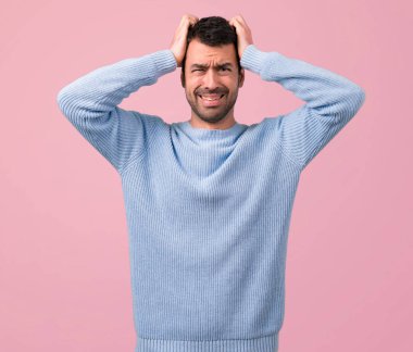 Yakışıklı adam mutsuz ve bir şey ile sinirli. Pembe bir arka plan üzerinde negatif yüz ifadesi