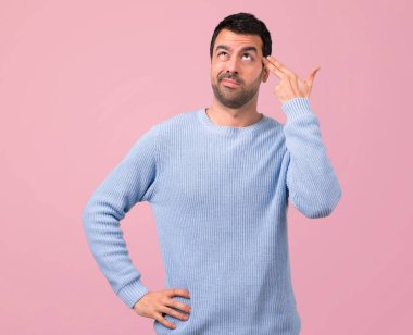 Adam mavi kazaklı mutsuz ifade verme intihar jest pembe bir arka plan ile sorunları ile