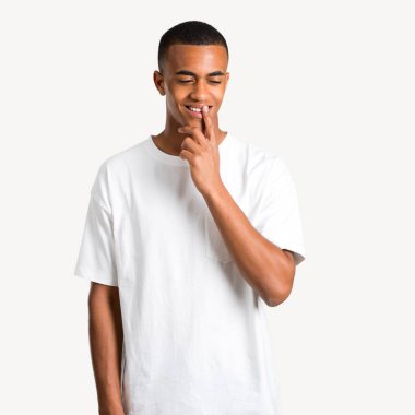 Genç Afro-Amerikan adam ayakta ve çene izole arka plan üzerinde el ile bakıyor