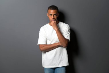 Gri duvar arka plan düşünme üzerine genç Afro-Amerikan adam