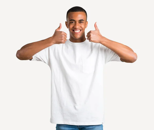 若いアフリカ系アメリカ人ジェスチャー親指を与えると孤立の背景に成功を収めているために 笑って — ストック写真
