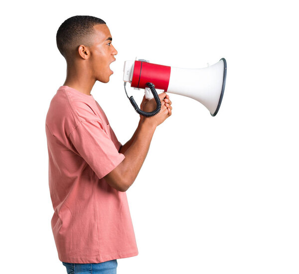Молодой африканский американец кричит через мегафон, чтобы объявить что-то в боковом положении на изолированном белом фоне
