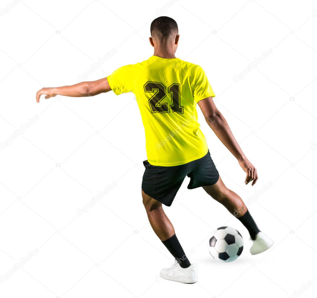 Soccer player man with dark skinned playing kicking the ball on isolated white background