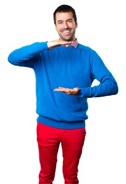 Bir şey beyaz arka plan üzerinde tutan yakışıklı genç