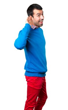 Beyaz arka planda bir şey dinlerken yakışıklı genç