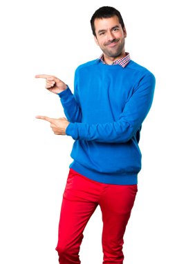 Beyaz arka planda lateral işaret eden yakışıklı genç