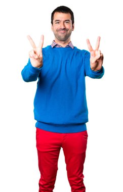 Yakışıklı genç adam yapma zafer jest beyaz arka plan üzerinde