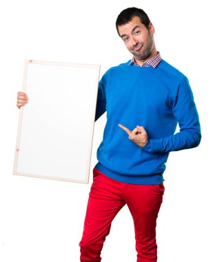 Boş bir afişini beyaz arka plan üzerinde tutarak yakışıklı genç