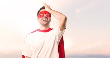 Süper kahraman maske ve kırmızı pelerin adamla bir şeyin farkına vardım ve günbatımı bir arka plan üzerinde çözüm isteyen vardır