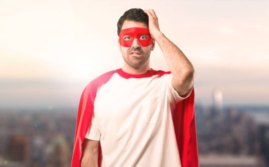 Süper kahraman maske ve kırmızı pelerin ile hayal kırıklığı ve anlayış değil bir ifadesi olan adam. Gün batımı bir arka plan üzerinde eller karıştı