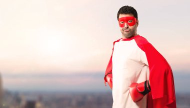 Süper kahraman adam maskesi ve kırmızı pelerin ve boks eldivenleri günbatımı bir arka plan üzerinde