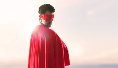 Süper kahraman adam maskesi ve kırmızı pelerin günbatımı bir arka plan ile