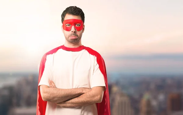 マスクと赤マントは 悲しい 落ち込んでいる表情で男はスーパー ヒーロー 夕日を背景に深刻なジェスチャー — ストック写真