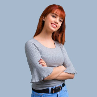 Silah tutan genç Kızıl saçlı kız mavi arka plan üzerinde çarpı işareti