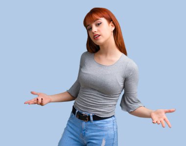 Genç Kızıl saçlı kızı gurur ve kendini beğenmiş kendini kavramı mavi zemin üzerine seviyorum