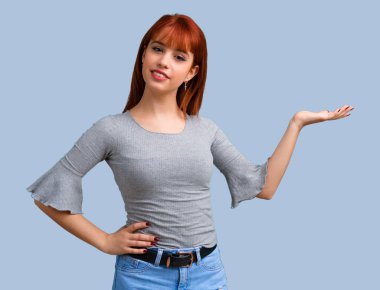 Mavi arka plan üzerinde Palm'da boşaltmak hayali tutan genç Kızıl saçlı kız