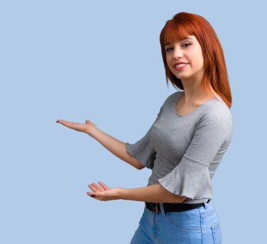 Sunulması ve mavi zemin üzerine gelmek için davet genç Kızıl saçlı kız