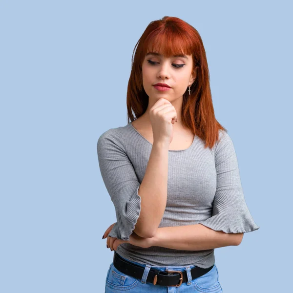 Giovane Rossa Ragazza Piedi Guardando Giù Sfondo Blu — Foto Stock