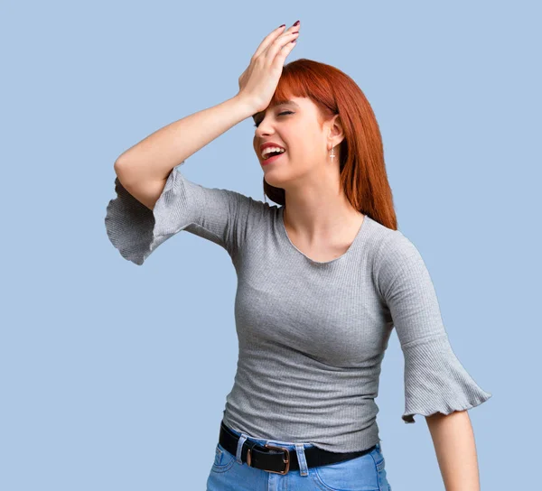 İsteyen genç Kızıl saçlı kız çözüm üzerinde mavi arka plan gerçekleştirmektedir.
