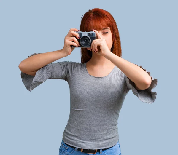 蓝色背景的年轻红发女孩拍摄 — 图库照片