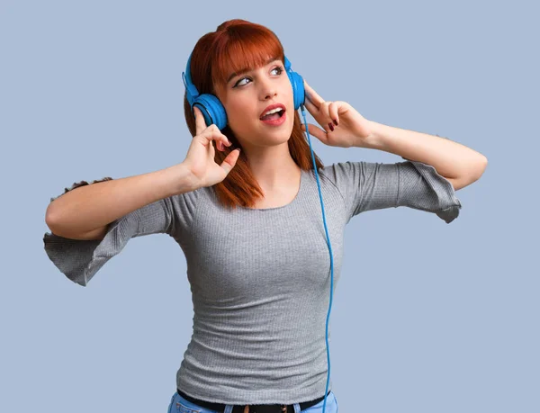 Young Redhead Girl Listening Music Headphones Blue Background — Stock Photo, Image