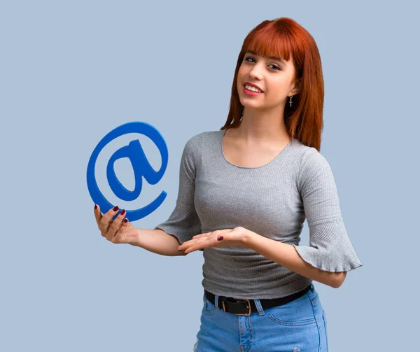 Young Redhead Girl Holding Icon Dot Com Blue Background — Stock Photo, Image