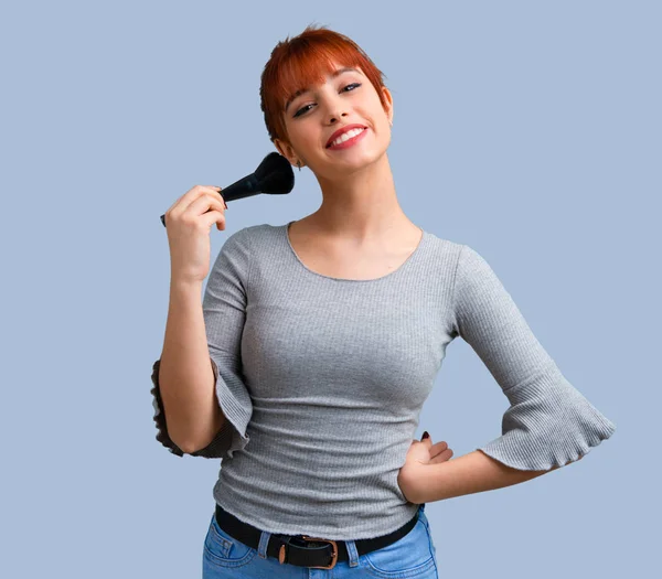 Chica Pelirroja Joven Con Cepillo Maquillaje Sobre Fondo Azul — Foto de Stock