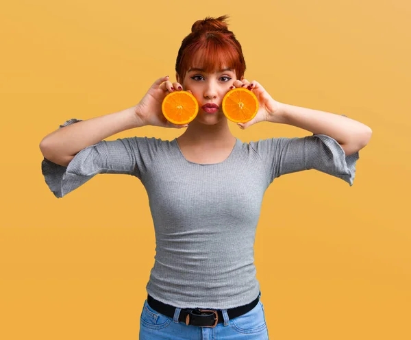 Joven Pelirroja Sosteniendo Una Naranja Sobre Fondo Naranja —  Fotos de Stock
