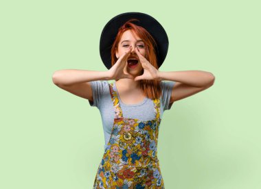 Şapka bağırarak ağzı açık olan serin Kızıl saçlı kız