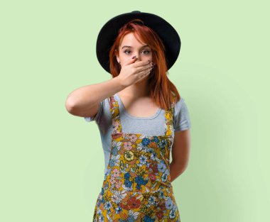 Ellerle ağız kapsayan şapka ile serin Kızıl saçlı kız