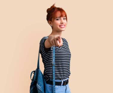 Genç öğrenci Kızıl saçlı kız puan parmak size koyu sarı zemin üzerine