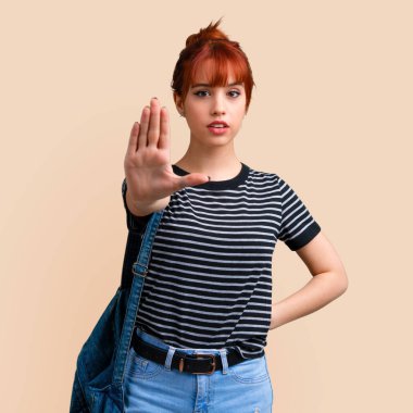 Genç öğrenci Kızıl saçlı kız yapma dur jest koyu sarı zemin üzerine eliyle