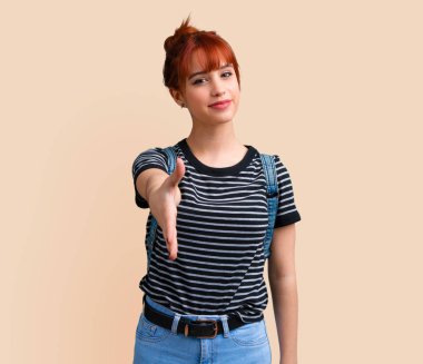 Genç öğrenci Kızıl saçlı kız el sıkışma koyu sarı arka plan üzerinde iyi bir anlaşma sonra