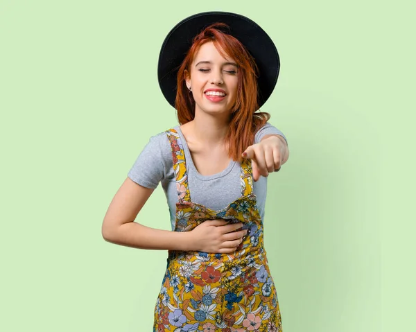 Birisi parmak ile işaret ve çok gülüyor şapka ile serin Kızıl saçlı kız