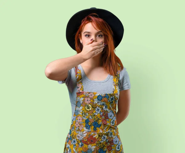 Ellerle ağız kapsayan şapka ile serin Kızıl saçlı kız