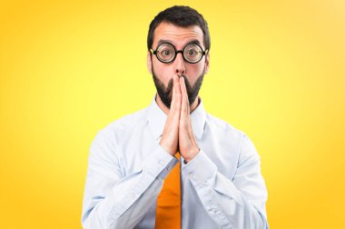 Renkli arka plan üzerinde yalvaran gözlüklü komik adam