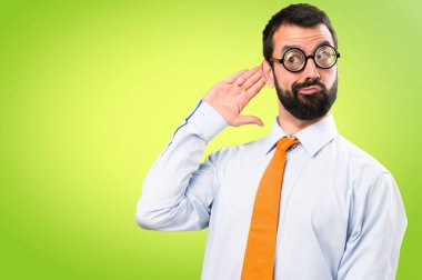 Komik adam gözlüklü bir şey renkli arka plan üzerinde dinleme