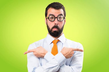 Renkli arka plan üzerinde şüpheleri Laterallerin işaret eden gözlüklü komik adam