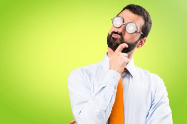 Komik adam gözlüklü renkli arka plan üzerinde düşünme