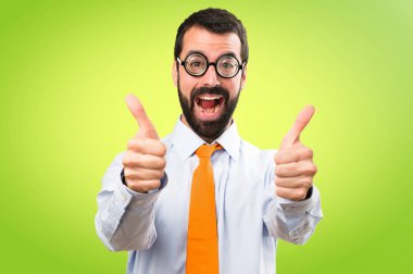 Renkli arka plan üzerinde başparmak ile gözlüklü komik adam