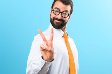 Komik adam ile yapım zafer jest renkli arka plan üzerinde gözlük