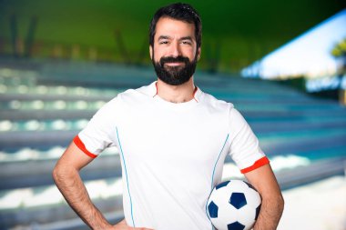 Bir futbol topu futbol sahasında sahip mutlu futbol oyuncu