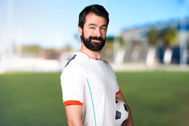 Bir futbol topu futbol sahasında sahip mutlu futbol oyuncu
