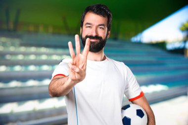 Üç deyince bir futbol sahası sayma bir futbol topu futbol oyuncu